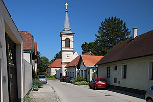 Winzendorf, Hauptstraße, im Hintergrund die alte Pfarrkirche